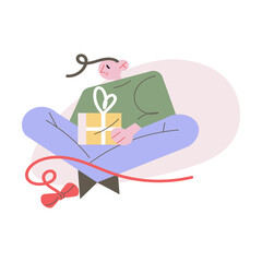 Happy boy sitting and decorating Christmas present box with bow