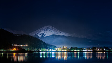 Superbe panorama sur le Mont Fuji vue de nuit depuis le lac de Kawagushiko avec la ville d'Oishi éclairée, Japon