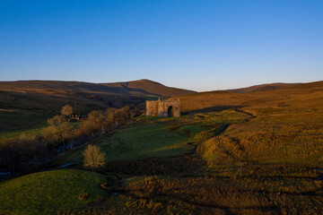 Medieval Castle in Scotland at sunrise with dramatic casting light 
