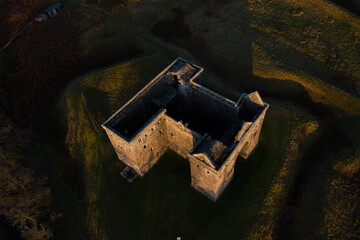 Medieval Castle from top down angle in Scotland at sunrise with dramatic casting light 