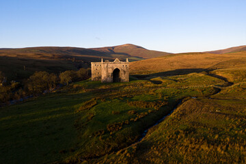 Medieval Castle in Scotland at sunrise with dramatic casting light 