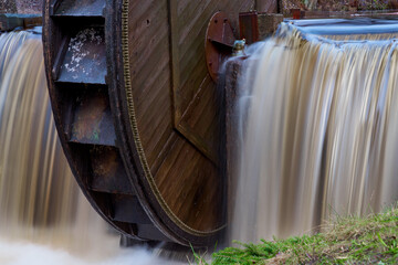 An old wooden water wheel on a waterfall.