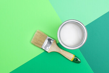 Open paint enamel cans on color palette samples. The concept of repair, construction. Shades of green.