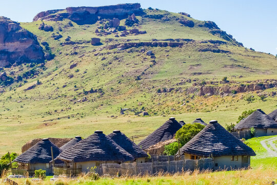 A small village of African rondavels on background of a rocky hill
