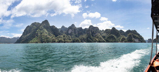 pano view from motor boat over lake of Khao Sok National Park and mountains