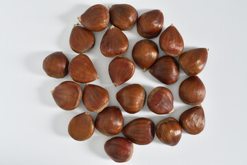 Un montón de castañas sobre fondo blanco.