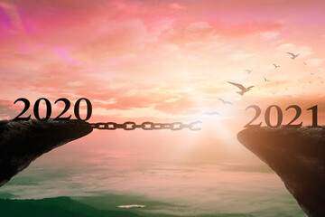 Success new year 2021 concept: Text 2020 and 2021 with bird flying and broken chains against mountain sunrise background