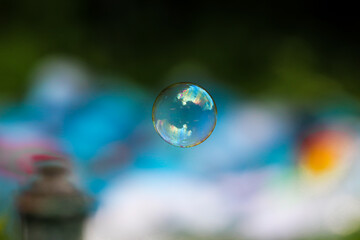 single big soap bubble in the air with blue blurred background