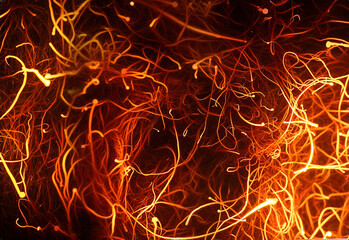 Abstract photograph of burning red and orange filaments on a black background