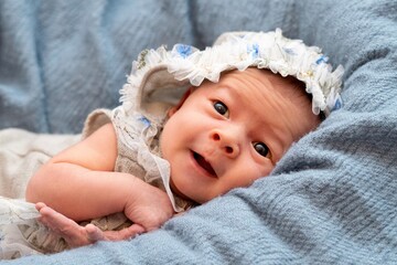 Fototapeta na wymiar Close up of newborn baby in light blue fluffy blanket. Portrait of pretty newborn baby.