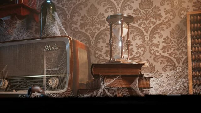 Antique hourglass on he vintage wooden desk in the old room. Abandoned office.