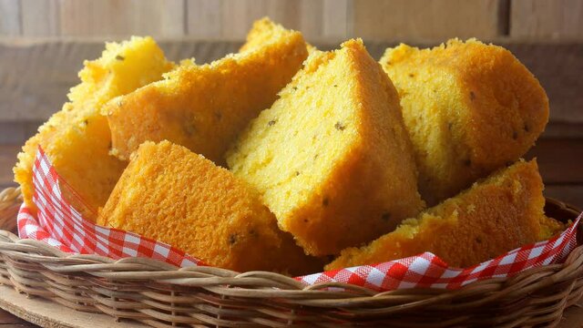 corn cake sliced in basket on rustic wooden table for breakfast. Typical Brazilian food