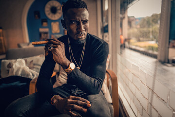portrait of african american man holding cigar on hand in coffee shop - Powered by Adobe