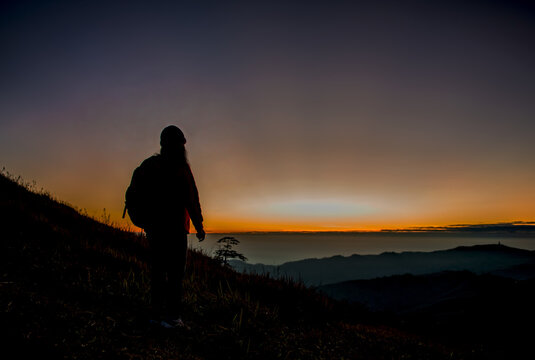 Female tourists with backpacks waiting to see sunrise on Viewpoint of the sunrise on Phu Lom Lo Phetchabun Province, Thailand