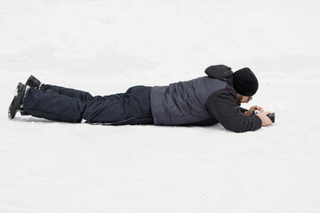 Fototapeta na wymiar Videographer lies in the snow