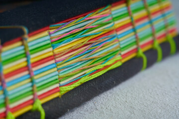 Closeup shot of the braided binding with woven thread and multicolored leaves. recycled book....