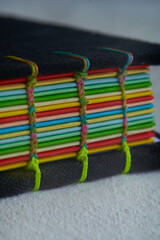 Closeup shot of a book with colorful paper bound with woven thread. handmade binding. recycled paper