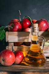 Apple cider vinegar, juice, homemade drink in a glass decanter and fruit in a wooden box