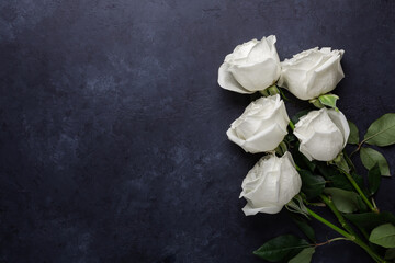 White rose flowers bouquet on black stone background