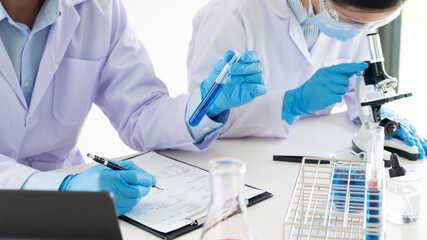 Team of Medical Research Scientists or researcher in lab coat testing their experimental in Modern...