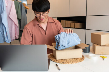 Asian business owner working at home with packing box of his online store prepare to deliver products to customers, alpha generation life style concept.