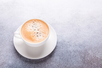 White cup of coffee on stone table. Top view