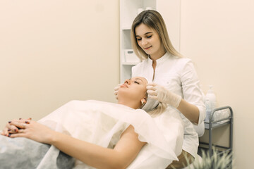 woman beautician prepares the patient for procedures