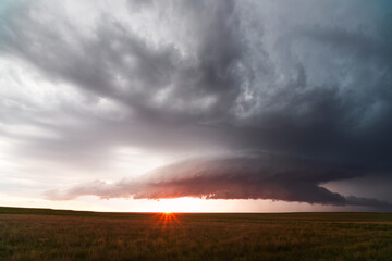 Supercell thunderstorm with dark storm clouds at sunset