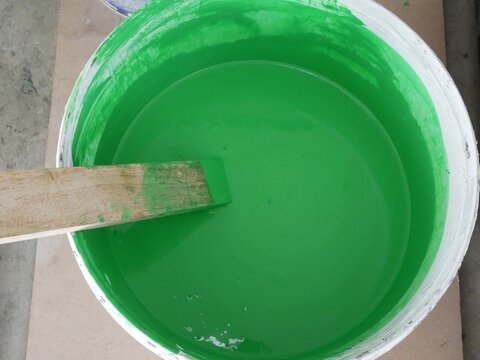 Green Paint In The Paint Bucket At Construction Site.