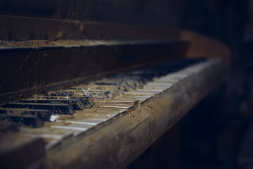A closeup shot of a piano in a creepy abandoned room inside of a building