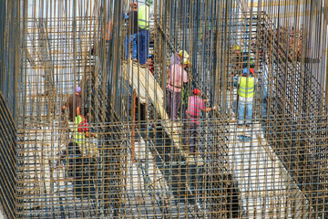 Construction workers fixing reinforcing steel bars for building armature - obrazy, fototapety, plakaty