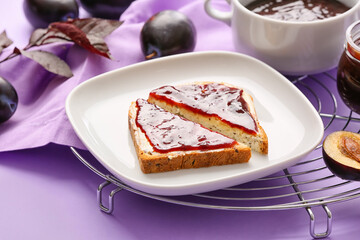 Slices of bread with delicious homemade plum jam on plate