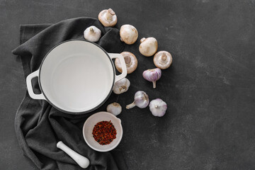 Obraz na płótnie Canvas Cooking pot and mushrooms on dark background