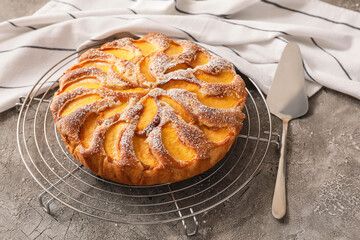 Tray with tasty peach pie on grunge background