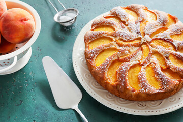 Plate with tasty peach pie on color background