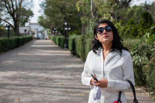 mujer joven de negocios caminando en el parque de la parroquia de santa mar&iacute;a magdalena en Tepetlaoxtoc texcoco