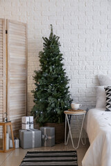 Beautiful Christmas tree with gift boxes in bedroom
