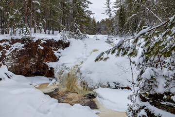 Fototapeta na wymiar Frozen over Amnicon River and waterfalls with fresh snow during winter at Amnicon Falls State Park in Douglas County Wisconsin 