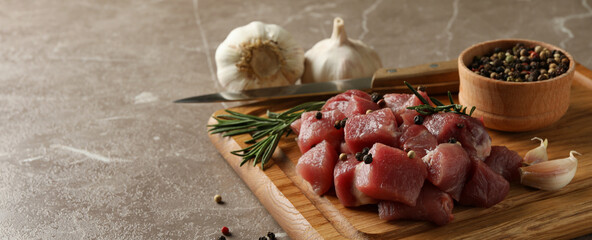 Board with raw meat, herbs and spices on gray background