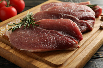 Board with fresh raw steak meat on wooden background
