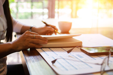 Businesswoman hand writing with document tax at work office.concept