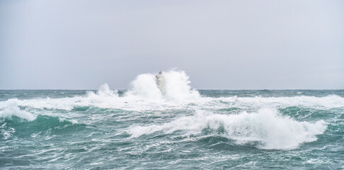 The lighthouse of the Mangiabarche shrouded by the waves of a mistral wind storm
