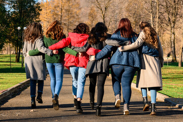 Young group of girls walking in autumn park, autumn clothes and autumn walk.