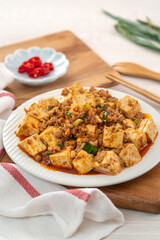 Mapo tofu, stir-fried tofu with hot spicy sauce in white plate.