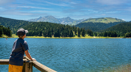 Fototapeta na wymiar boy looking lake of Payolle in the french Pyrenees