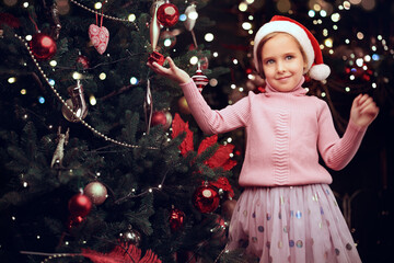 girl decorates xmas tree