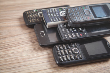 Old cell phones on wooden background.