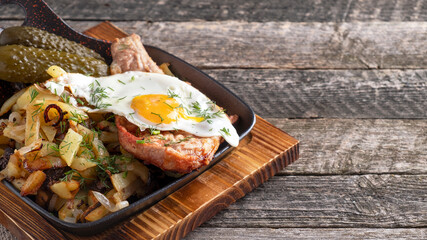 Roasted meat with egg and potatoes on a frying pan. Space for text