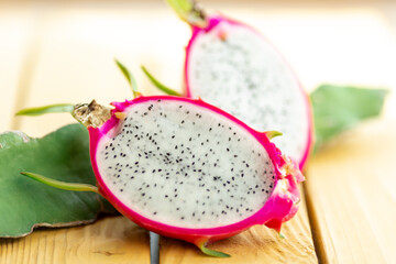 Bisected close up dragon fruit with branch, yellow background