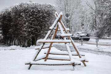 Empty wooden frame for haystack covered with snow in winter. Urban design object on rural country...